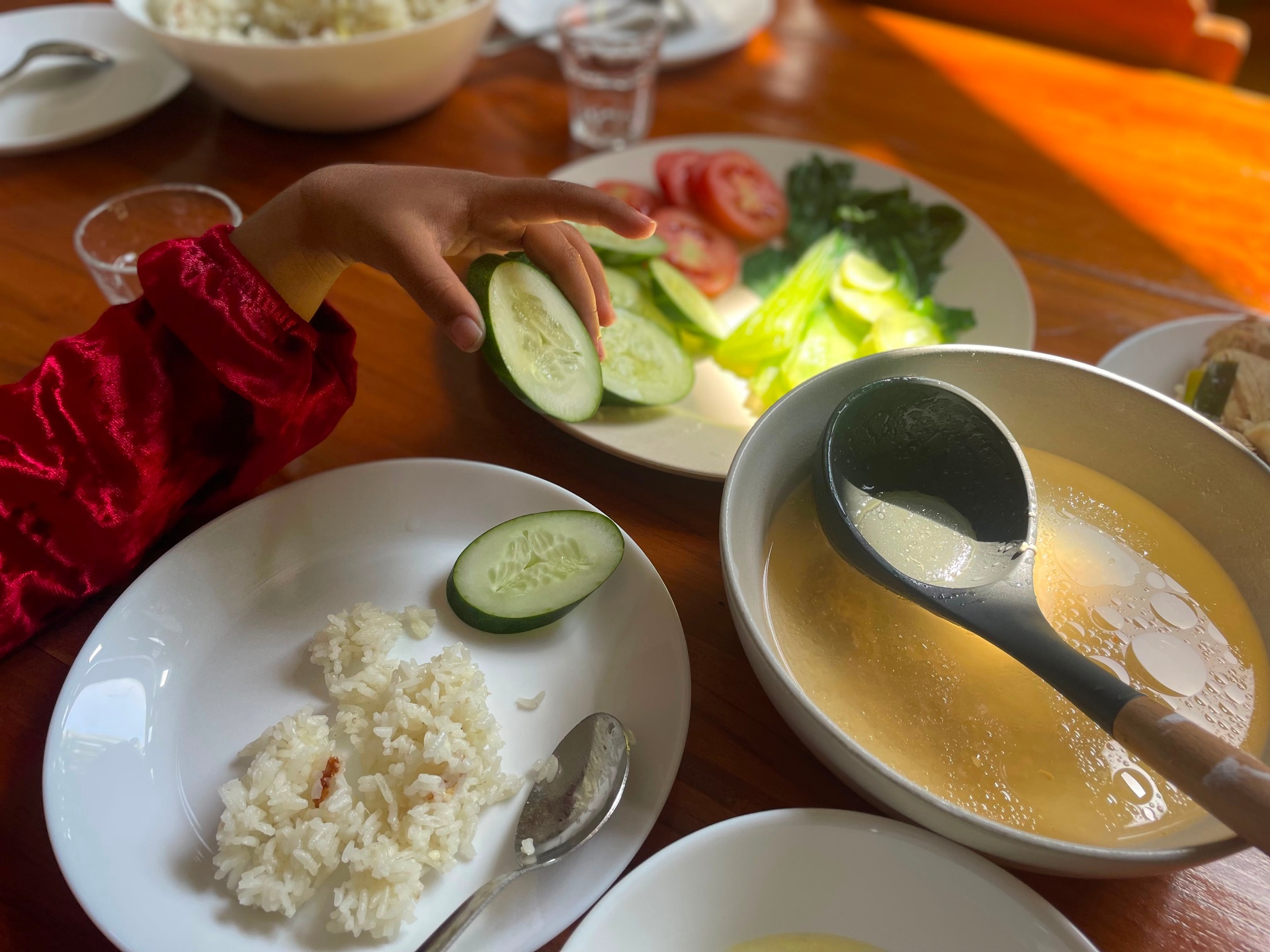 A plate of steamed greens, cucumber and tomato prepared in the Untuk Anak kitchen