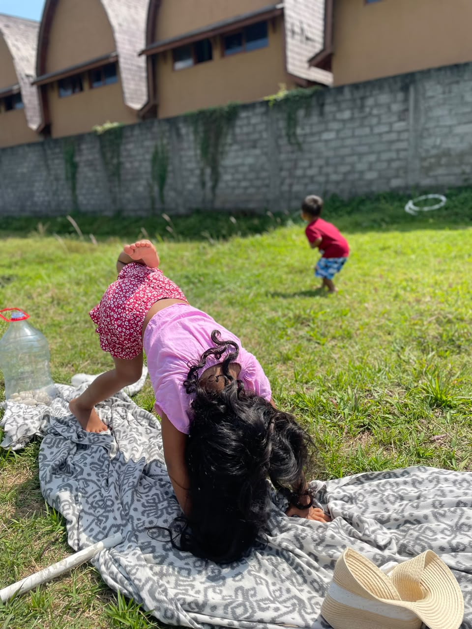 A child moving and stretching on a blanket in the garden