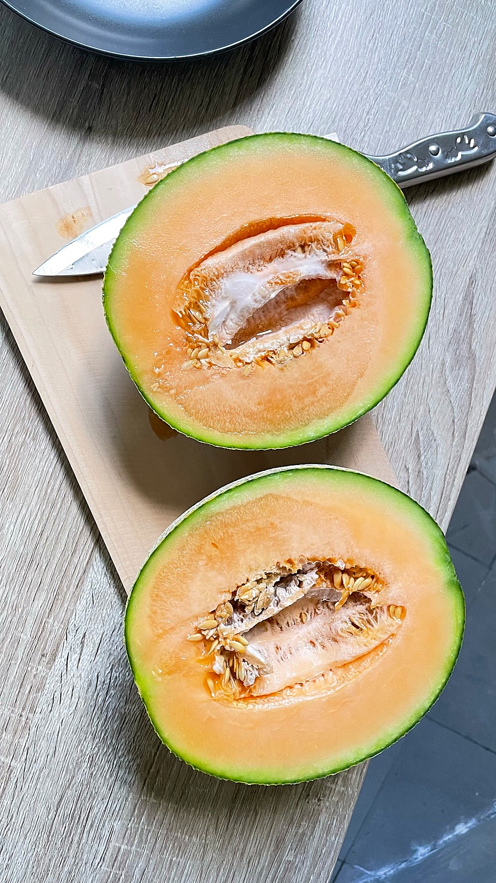 Fresh honeydew melon halved on a wooden board